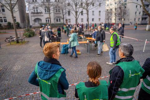 Während sich Menschen Lebensmittel aussuchen, die sonst weggeworfen worden wären, warten die Aktiven von Foodsharing auf dem Riegerplatz auf den nächsten ihrer Transporter. Foto: Marc Wickel