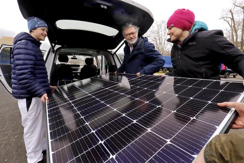 Juraj und Alexander Marschall haben zwei Stecker-Solarmodule erstanden. Marie Mittenzwei von der Initiative Heiner-Energie hilft beim Beladen der Autos.