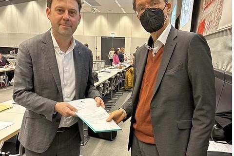 Dr. Jens Zimmermann (SPD, links) übergibt den offenen Brief der Pflegekräfte aus den Kreiskliniken Darmstadt-Dieburg an Bundesgesundheitsminister Karl Lauterbach (SPD). 