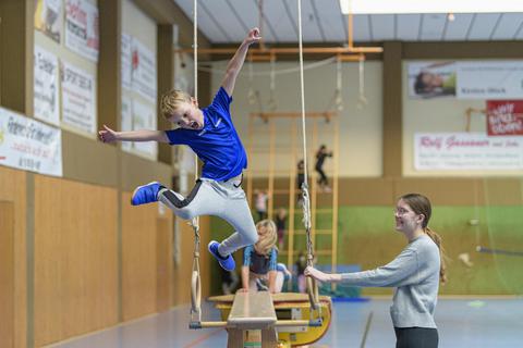 Spaß hat der siebenjährige Johann bei dieser Balance-Übung mit abschließendem Sprung. Rechts Trainerin Ann-Kathrin Knell. Foto: Robert Heiler