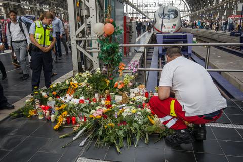 Ein Ersthelfer, der am Tag zuvor vor Ort war, legt am Bahnsteig 7 im Frankfurter Hauptbahnhof Blumen nieder. Foto: dpa