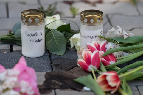 Kerzen und Blumen erinnern nach dem gewaltsamen Tod zweier Kinder auf dem Innenhof eines Hochhauses in Hanau an die Opfer. Während die genauen Hintergründe der Tat noch unklar sind, geht die Polizei von einem familiären Hintergrund aus und fahndet nach einem Tatverdächtigen.  Foto: dpa