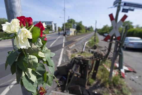 Blumen stecken am Unglücksort am Bahnübergang in Frankurt-Nied, wo bei einem Unfall wegen einer geöffneten Schranke eine 16-Jährige tödlich verletzt worden war. Foto: dpa
