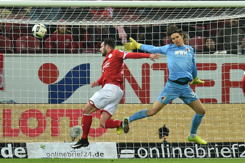 05-Spieler Levin Öztunali köpft den Treffer zum 1:0 gegen Augsburgs Marwin Hitz. Foto: dpa