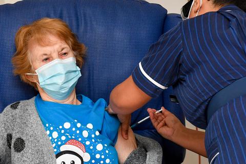 Die 90-jährige Margaret Keenan (links) bekommt im Universitätskrankenhaus Coventry von der Krankenschwester May Parsons den Pfizer/BioNtech-Impfstoff gegen das neuartige Coronavirus. Keenan ist die erste Patientin im Vereinigten Königreich, die zu Beginn des größten Impfprogramms in der Geschichte des Vereinigten Königreichs mit dem Corona-Impfstoff von Biontech und Pfizer geimpft wurde. Foto: dpa