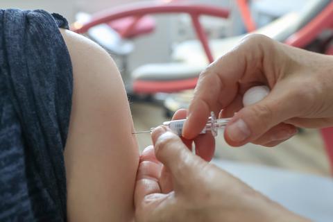 Eine Frauenärztin impft eine Schwangere gegen Grippe. Foto: dpa