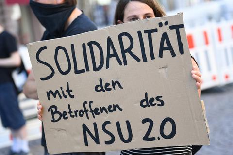 Ein Demonstrantin hält während einer früheren Kundgebung in der Wiesbadener Innenstadt ein Plakat mit der Aufschrift «Solidarität mit den Betroffenen des NSU 2.0». Ein mutmaßlicher Verfasser von rechtsextremen Drohschreiben mit dem Absender «NSU 2.0» ist in Berlin bei einer Wohnungsdurchsuchung festgenommen worden.  Foto: Arne Dedert/dpa  