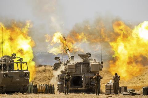 Israelische Soldaten halten sich die Ohren zu, während ein Artilleriegeschütz auf Ziele im Gazastreifen feuert. Seit dem 10. Mai beschießen militante Palästinenser Israel mit Raketen. Israels Armee reagiert darauf mit Angriffen auf Ziele im Gazastreifen, vor allem durch die Luftwaffe. Auf beiden Seiten gab es Tote. Foto: Yonatan Sindel/AP/dpa