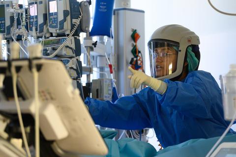 Eine Fachärztin ist auf der Covid-19 Intensivstation im Städtischen Klinikum Dresden mit der Versorgung eines Corona-Patienten beschäftigt.  Foto: Robert Michael/dpa-Zentralbild