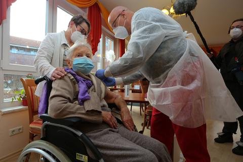 Die Heimbewohnerin Edith Kwoizalla ist mit ihren 101 Jahren die Erste, die am Samstag vor dem offiziellen Impfstart in Deutschland gegen Corona geimpft wurde. Im Landkreis Harz in einer Senioren Pflegeeinrichtung in Halberstadt wurden die ersten Bewohner sowie das Pflegepersonal mit dem Covid-19 Impfstoff von Pfizer-Biontech geimpft. Der Arzt Dr. Bernhard Ellendt (rechts) nahm die Impfung vor. Foto: dpa
