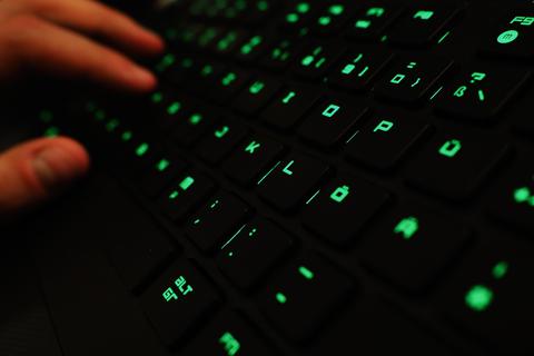 Ein Mann tippt auf einer beleuchteten Tastatur.  Foto: dpa
