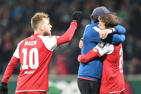 Aufatmen: Der Mainzer Trainer Sandro Schwarz umarmt nach Spielende den Torschützen zum 2:2 Fabian Frei (r.), links steht Alexandru Maxim. Foto: dpa
